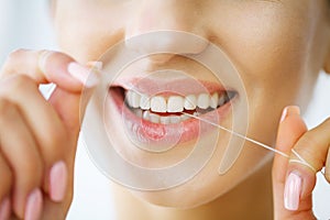 Teeth Care. Beautiful Smiling Woman Flossing Healthy White Teeth