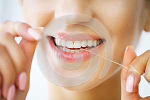 Teeth Care. Beautiful Smiling Woman Flossing Healthy White Teeth