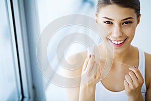 Teeth Care. Beautiful Smiling Woman Flossing Healthy White Teeth