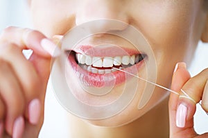 Teeth Care. Beautiful Smiling Woman Flossing Healthy White Teeth