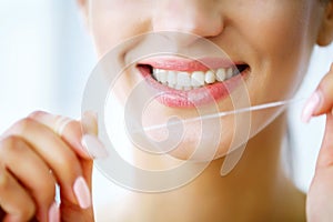 Teeth Care. Beautiful Smiling Woman Flossing Healthy White Teeth