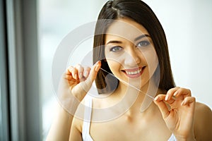 Teeth Care. Beautiful Smiling Woman Flossing Healthy White Teeth