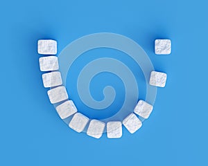 Teeth made of sugar cubes on blue background, two teeth missing. Sweet tooth dental health care concept