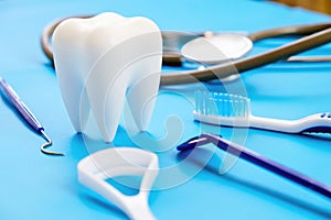 Teeth model and dentist tools on blue background.