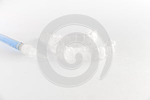 Teeth tray for dental whitening opalescence and bleaching gel syringe on white background