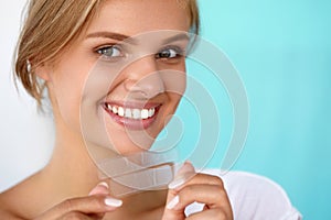 Teeth Whitening. Beautiful Smiling Woman Holding Whitening Strip