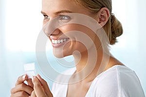 Teeth Whitening. Beautiful Smiling Woman Holding Whitening Strip