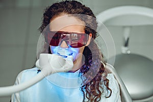 Teeth whitening for woman. Bleaching of the teeth at dentist clinic. Front view