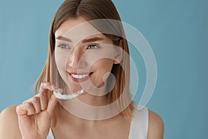 Teeth whitening. Woman with healthy teeth using removable braces