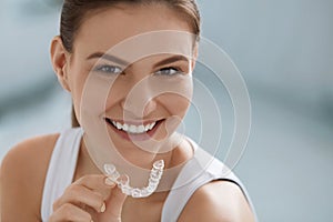 Teeth whitening. Woman with healthy teeth using removable braces photo