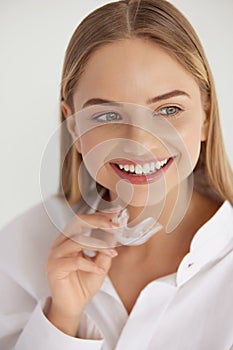 Teeth Whitening. Woman with White Smile, Using Removable Braces photo