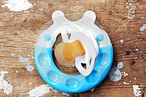 Teether and soother on wooden background