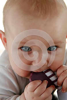 Teething baby boy with a toy