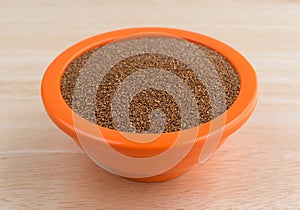 Teff grain filling a small bowl on wood table top