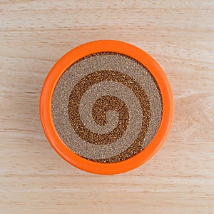 Teff grain filling a small bowl on wood table top