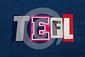 TEFL text word collage, multi colored fabric on blue denim, teach english as a foreign language acronym