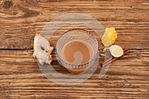 Teh tarik, ginger tea in glass on brown wooden table. Popular drink in Brunei, Malaysia and Singapore. Top view, Selective focus