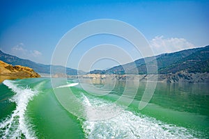 Tehri Lake, water surface behind of fast moving motor boat in Tehri lake. Trail on water surface behind speed boat. Rear view of