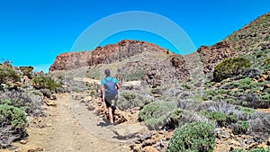 Teide - Man with backpack hiking to Riscos de la Fortaleza near Pico del Teide, Mount El Teide National Park, Tenerife,