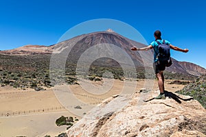 Teide - Man on rock with view on La Canada de los Guancheros dry desert plain and volcano Pico del Teide photo