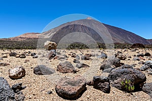 Teide - Pumice stones on desert plain La Canada de los Guancheros. Scenic view on volcano Pico del Teide photo