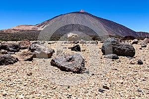 Teide - Pumice stones on desert plain La Canada de los Guancheros. Scenic view on volcano Pico del Teide photo