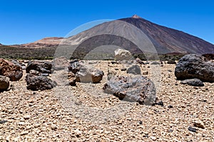 Teide - Pumice stones on desert plain La Canada de los Guancheros. Scenic view on volcano Pico del Teide photo