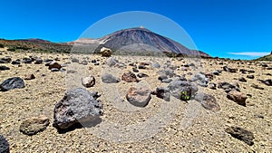 Teide - Pumice stones on desert plain La Canada de los Guancheros. Scenic view on volcano Pico del Teide photo