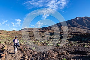 Teide - Woman with backpack hiking with scenic morning view on ummit of Pico del Teide, Tenerife.