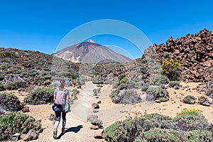 Teide - Woman on hiking trail La Fortaleza from El Portillo. Panoramic view on volcano Pico del Teide photo