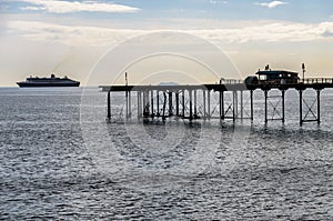 Teignmouth pier with redundant cruise ship