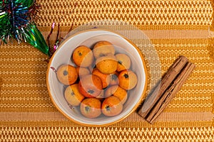 Tejocote fruits in a bowl, traditional mexican pinata and cinnamon photo