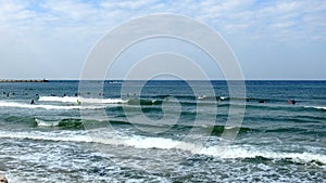 Tel Aviv. Blue sky. White clouds. Birch water. The sun. The waves. Surfing.