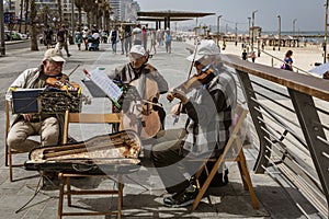 Tel Aviv, Israel - 2019-04-27 - String trio composed of elderly men play on the beach boardwalk