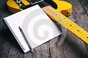 Telecaster with notepad on wood table