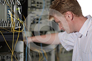 Telecom engineer looks on multiplexer