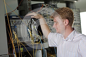Telecom engineer looks on multiplexer photo