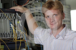 Telecom engineer poses on multiplexer background photo