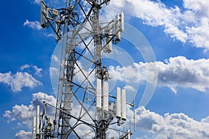 Telecom maintenance. Man climber on tower against blue cloudy sky background