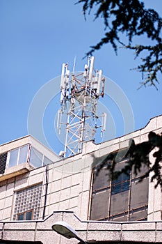 Telecommunication base stations network repeaters on the roof of building. The cellular communication aerial on city building roof