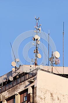 Telecommunication base stations network repeaters on the roof of building. The cellular communication aerial on city building roof