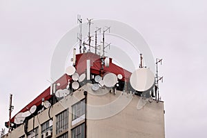 Telecommunication base stations network repeaters on the roof of building. The cellular communication aerial on city building roof