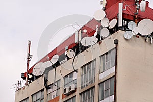 Telecommunication base stations network repeaters on the roof of building. The cellular communication aerial on city building roof