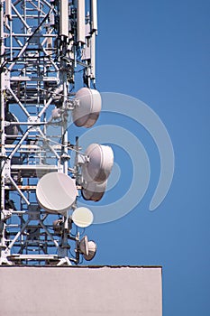 Telecommunication base stations network repeaters on the roof of building. The cellular communication aerial on city building roof