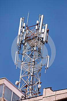 Telecommunication base stations network repeaters on the roof of building. The cellular communication aerial on city building roof