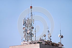 Telecommunication base stations network repeaters on the roof of building. The cellular communication aerial on city building roof