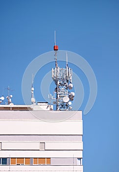 Telecommunication base stations network repeaters on the roof of building. The cellular communication aerial on city building roof