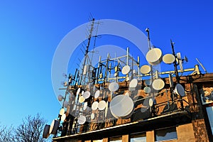 Telecommunication and microwave antennas and dishes installed on upper station of aricable. Evening sunlight and blue skies during