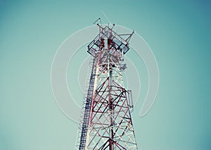 Telecommunication radio signal tower over the blue sky