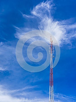 Telecommunication radio wave signal tower red and white with cloudy. Steel truss of transmission signal antenna with blue sky.